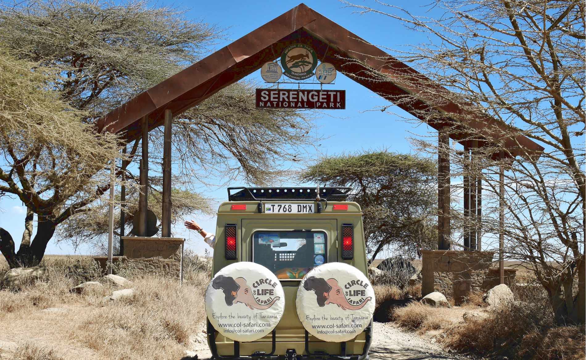 Ein Safariauto von Cirlce of Life Safari Tansania steht vor dem Eingang der Serengeti