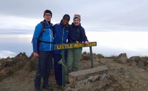 Eine Gruppe Bergwanderer steht vor dem Schild des Little Meru auf 3.820 Metern.
